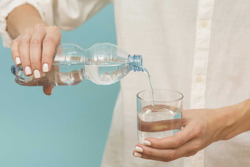Woman Pouring Water Into Glass 1024x683
